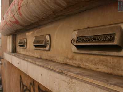 E� arrivato il momento di uscire: scendiamo le scale e ci immettiamo su via Nicolai. Qui, all'estremit� del portico d'ingresso e al cospetto del via vai continuo di gente, ci accorgiamo dell'esistenza di vecchie buche per le lettere in pietra bianca a lungo occultate ma riportate alla luce in seguito ai lavori di restauro